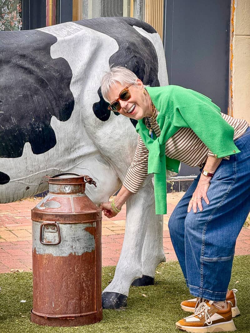 Susan B attempts to milk a plastic cow.
