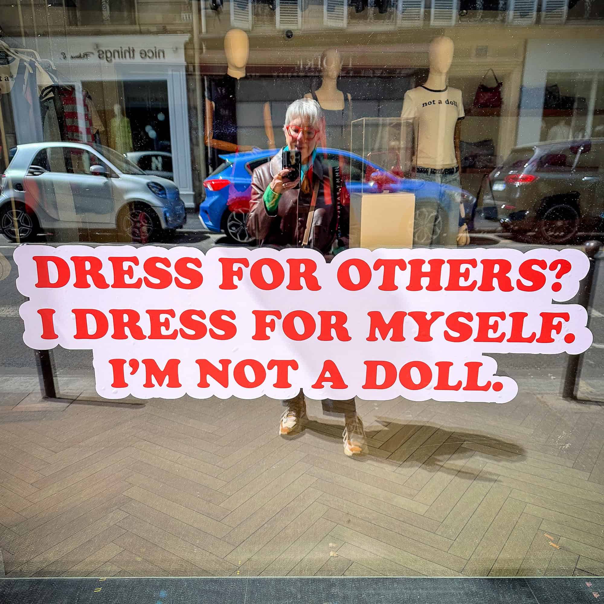 Susan B. takes a photo of a sign in Paris shop window.