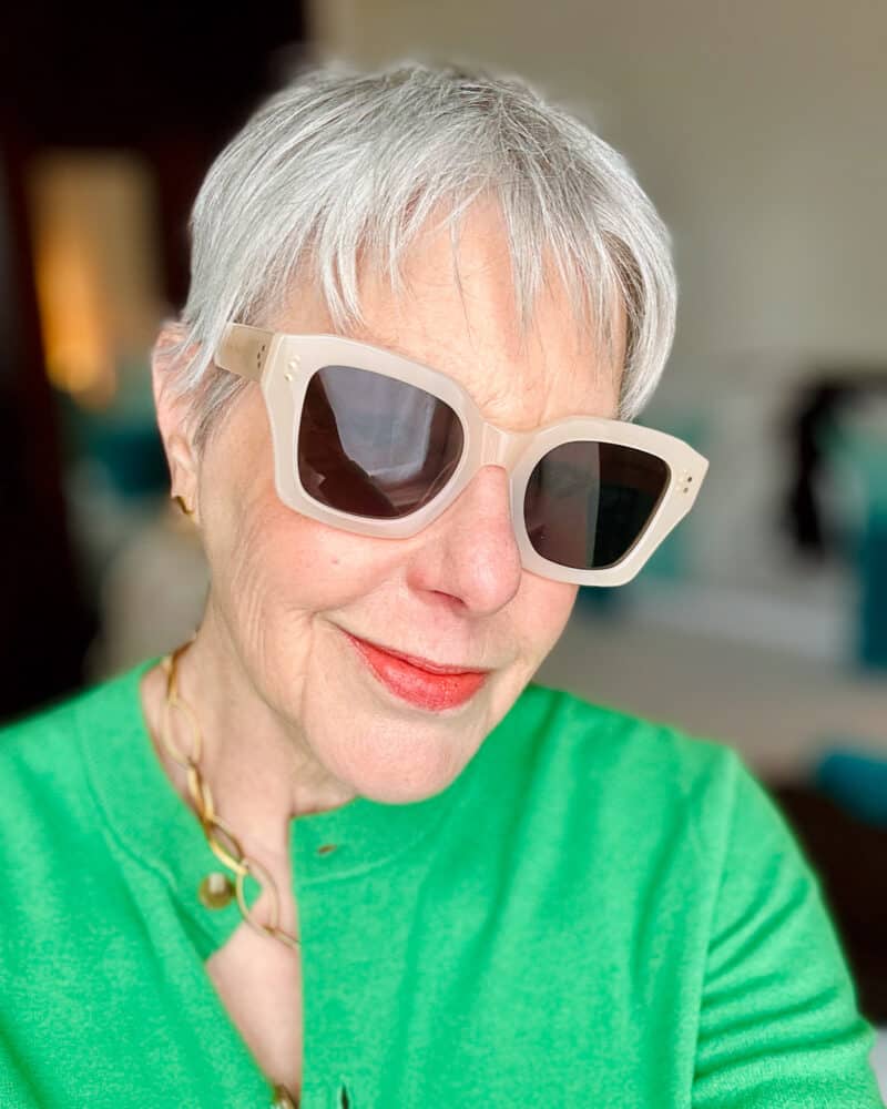 Susan B. wears Jimmy Fairly sunglasses and a green sweater