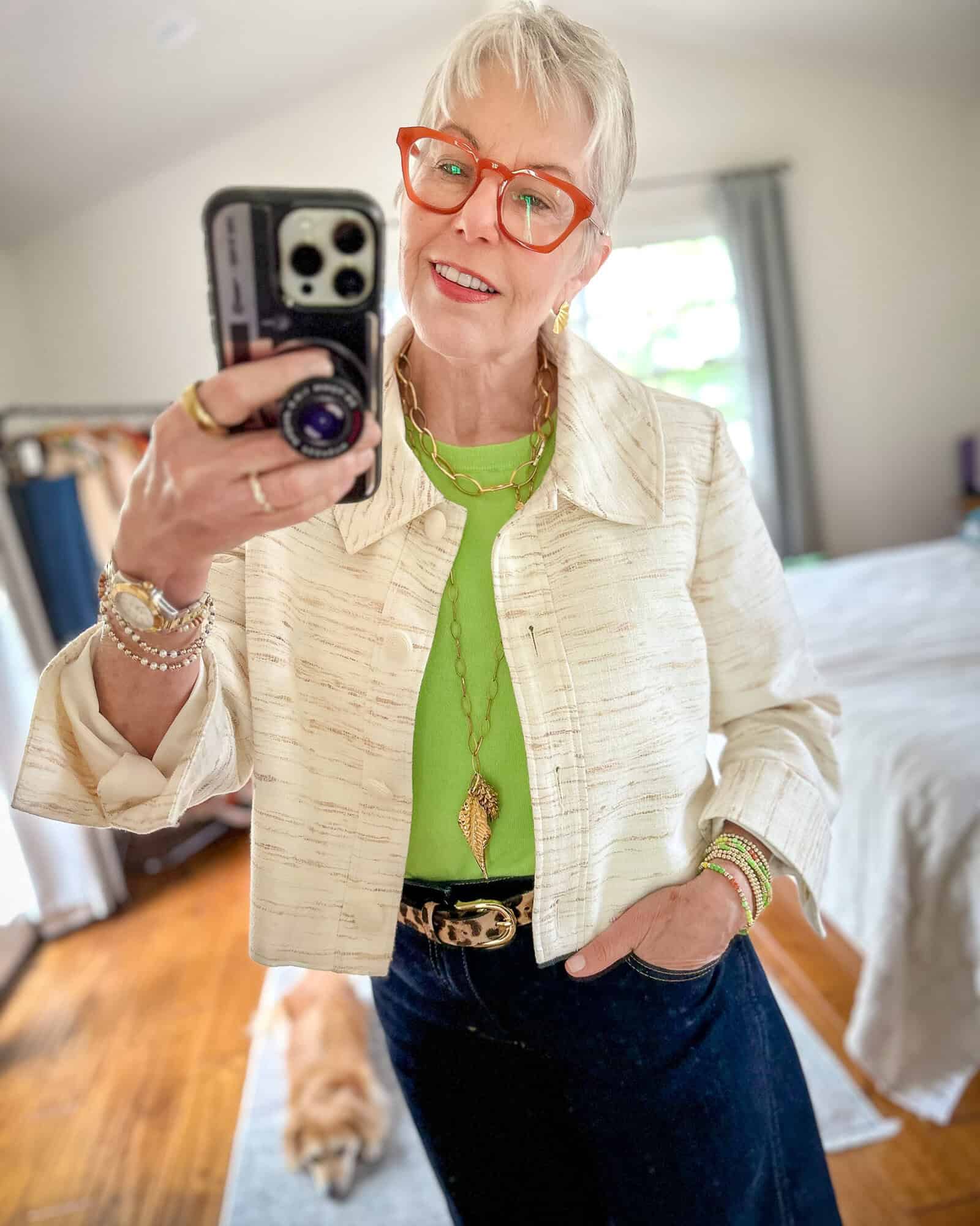 Susan B. wears a Sezane swing jacket, green cashmere shell, leopard belt, dark wash jeans, gold necklaces from Tarra Rosenbaum.