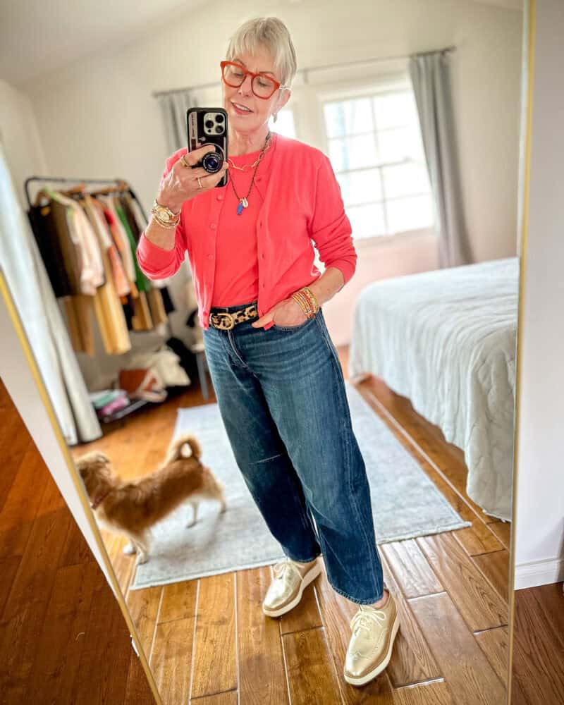 Modern casual outfit idea with a lightweight cashmere twinset. Susan B. wears a pink cardigan and shell with leopard belt, blue jeans, and metallic gold oxfords.