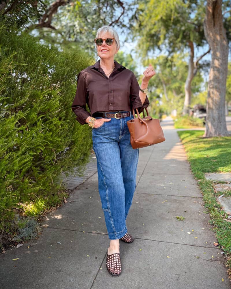 Everyday outfit with brown shirt, barrel-leg jeans, and flats, worn casually outdoors