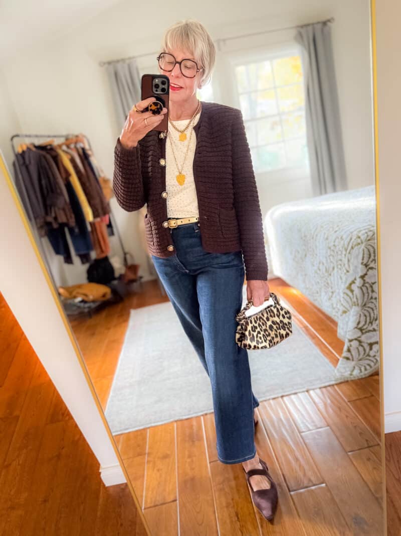Susan B wears a textured cardigan, layered gold necklaces, metallic dot tee, straight leg jeans, pointed toe flats, carries a leopard print bag.