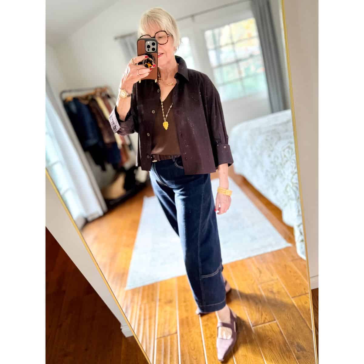 Warm weather holiday outfit idea with a crystal studded shirt, silk tank, sparkly jewelry & dark wash barrel jeans.