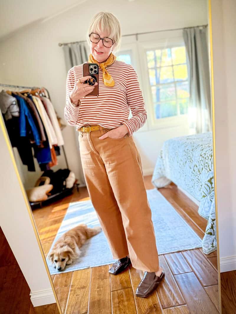 Susan B. wears a mustard silk scarf with a striped tee and colored denim barrel jeans.