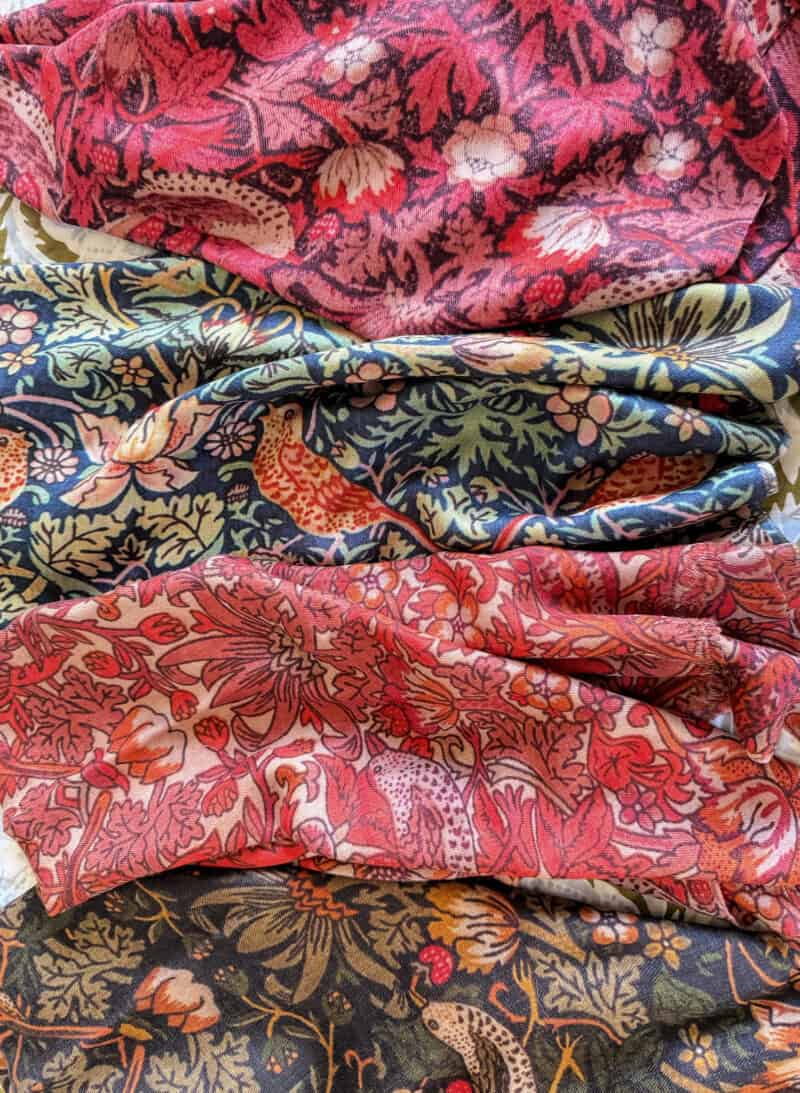 Four colorways of cashmere-silk Liberty "Strawberry Thief" print scarves.