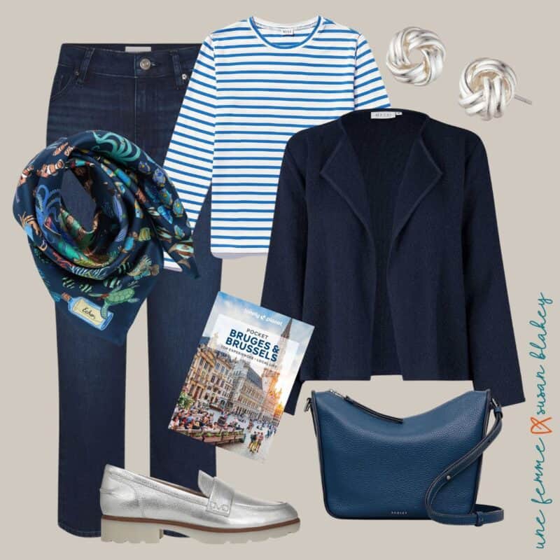 Spring travel outfit idea featuring a cool color palette with navy jeans, a striped tee, navy jacket, silver loafers, blue crossbody bag, silk scarf, and silver knot earrings.