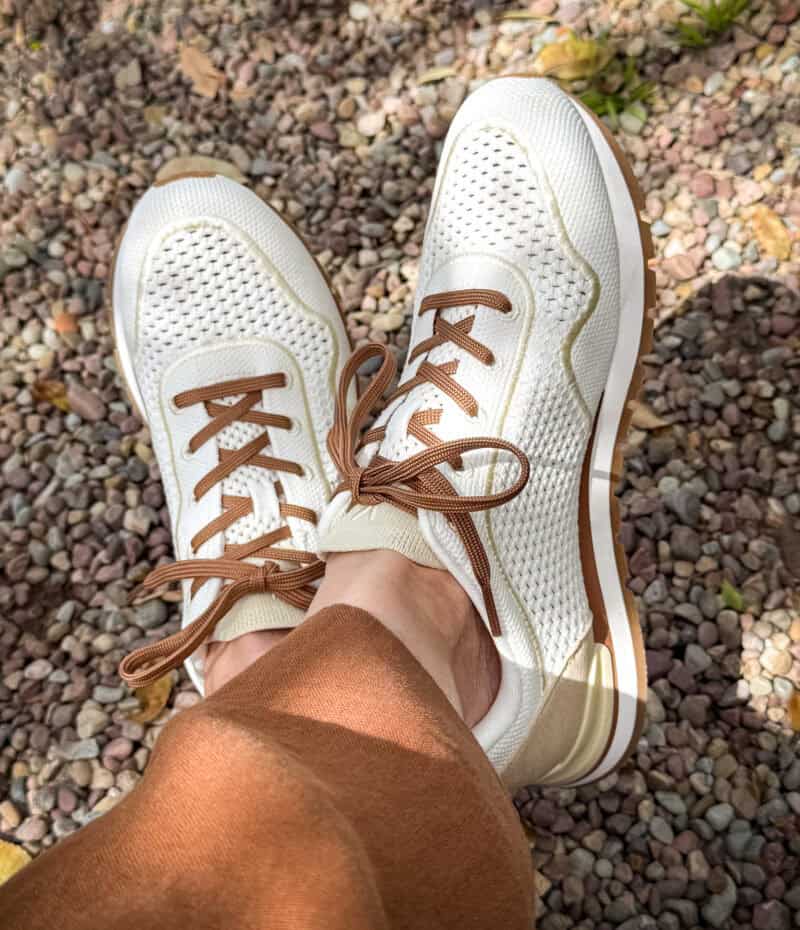 Detail: Susan B. wears Vivaia white mesh sneakers with brown laces.