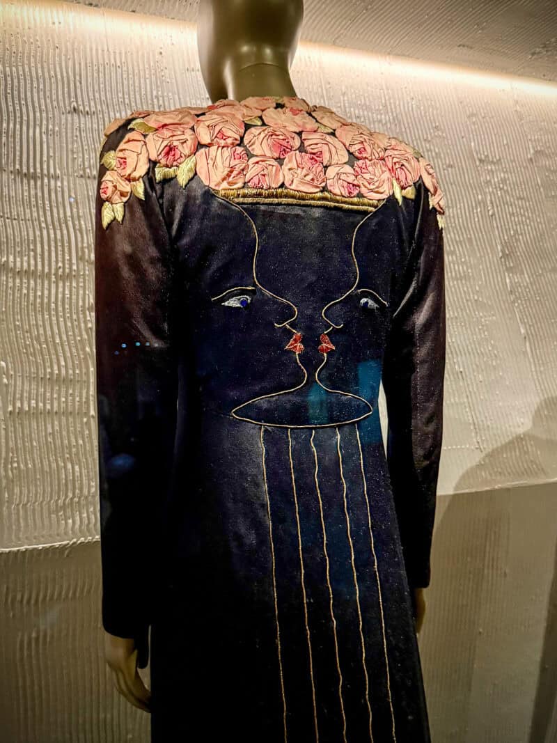 Back of Shiaparelli black velvet dress with fabric roses and faces embroidery.