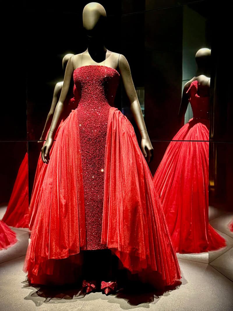Red gown from the Schiaparelli exhibition with high heel shoe detail on back of dress.