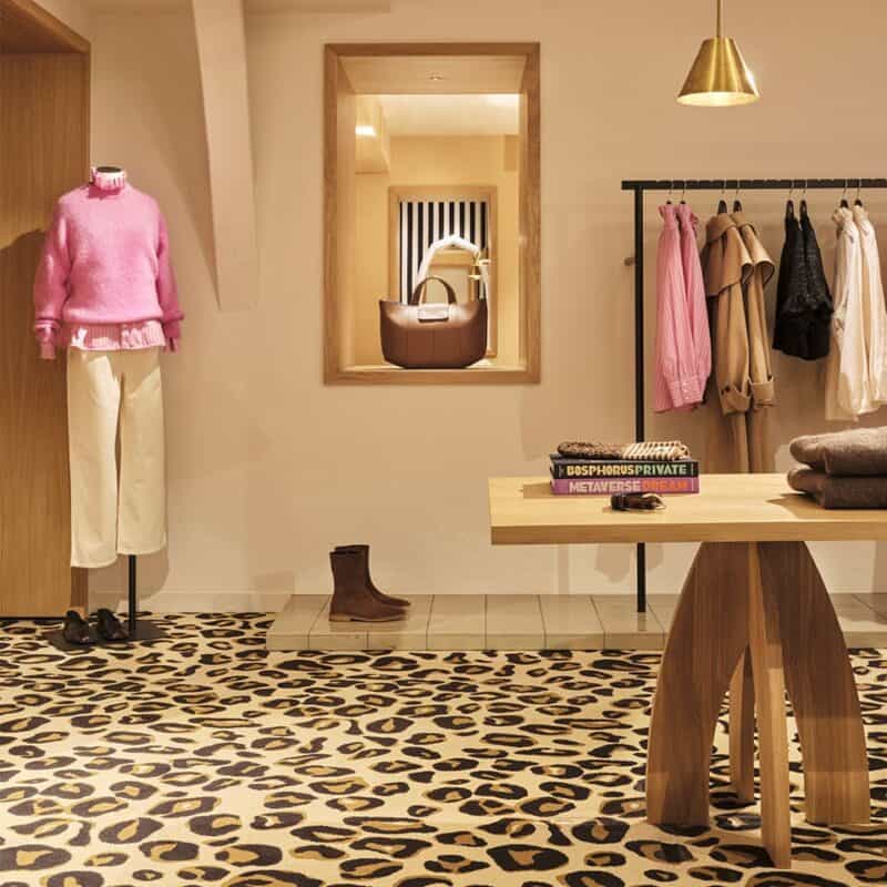 Interior shot of Balzac store in Paris with mannequin wearing a pink sweater and ivory pants.