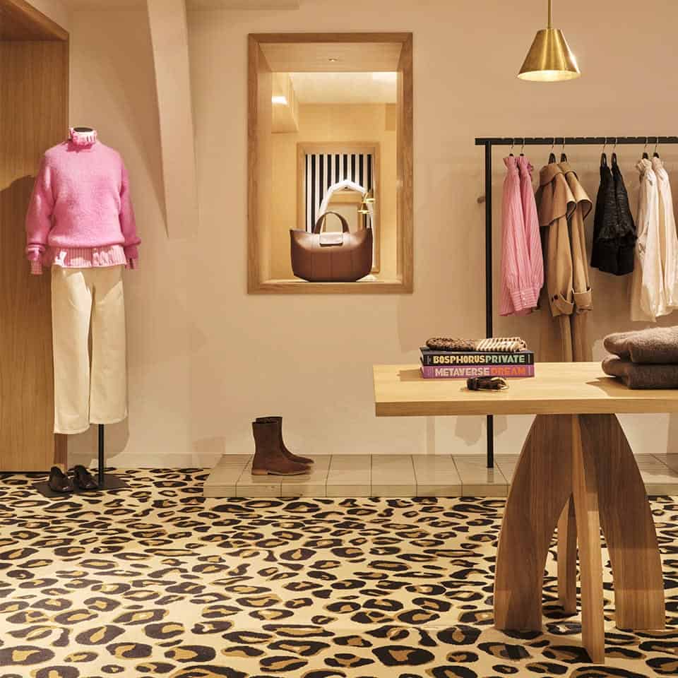 Interior shot of Balzac store in Paris with mannequin wearing a pink sweater and ivory pants.