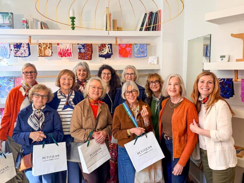 Paris Fashion Tour group poses with shopping bags at Petitjean scarves showroom in Paris.