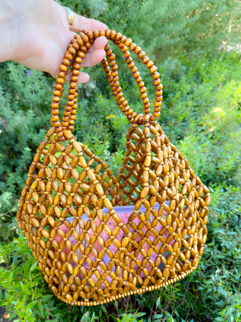 brown beaded tote bag with pink cloth pouch inside.