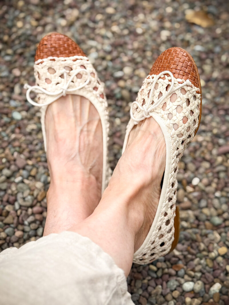 Detail of Margaux Demi open weave leather ivory ballet flats with a tan cap toe.