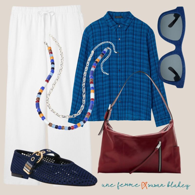 Cool-toned summer outfit collage: white linen drawstring pants, an Eileen Fisher blue plaid shirt, blue denim-textured sunglasses, beaded necklaces in shades of blue, red, and orange with silver chain, navy woven mary jane flats with buckle detail, and an oxblood leather shoulder bag.