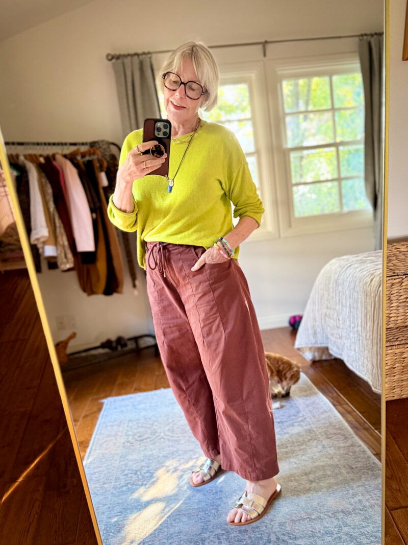 Chartreuse linen sweater with rust-colored wide-leg drawstring pants and metallic sandals.
