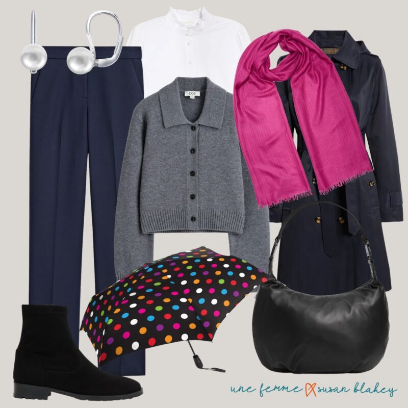 Fall travel outfit idea with navy pants, white shirt, grey cardigan, pink scarf, navy trench, black boots, polka dot umbrella, black bag.